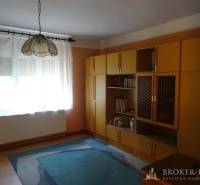 A room in a family house with modular furniture, a carpet, and pendant lighting.