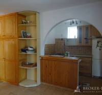 Interior of a family house with a kitchen, wooden furniture, and an arched passage.