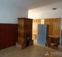 Interior of a family house with a fireplace stove, built-in furniture, and a tiled floor.