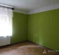 A room in a family house with a wooden floor and green walls.