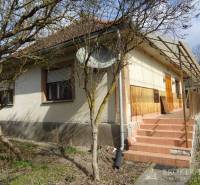 A family house in Füzérkomlós with a front garden, terrace, staircase, and wooden cladding.