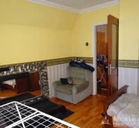 A room in a family house with yellow walls and a treadmill.
