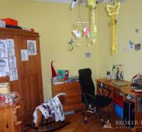 A room in a family house with a desk, chair, and a bulletin board decorated with pictures.
