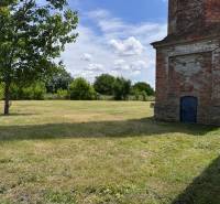 A grassy area with a brick building on Zemianske Sady street in Zemianske Sady.