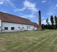 White building with a chimney on Zemianske Sady street in Zemianske Sady, Warehouses and halls.