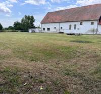 A building with a grassy plot on Zemianske Sady Street in Zemianske Sady near warehouses and halls.