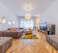 Living room in a two-room apartment with a comfortable sofa, television, and colorful cushions.