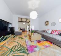 Living room in a two-room apartment with a colorful carpet and a sofa.