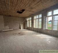 A spacious room with large windows and a wooden ceiling in a family house.
