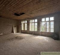 A spacious room with large windows and unfinished walls in a family house.