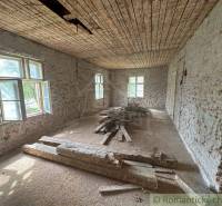 An older room in a family house with exposed bricks and wood on the floor.