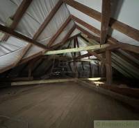 Attic of a family house with wooden beams and floor.