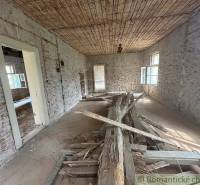 Interior of a family house with brick walls and a broken floor.
