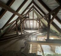 The attic of a family house with a staircase and wooden beams.