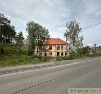 A family house in Rimavská Sobota by the road, surrounded by trees and grass.