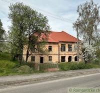 A family house in Rimavská Sobota with trees, in front of which there is a road and a fence.