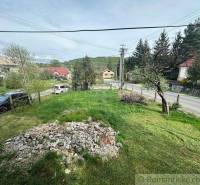 A garden of a family house in Rimavská Sobota with a lawn and gravel near the road.