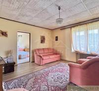 A living room in a family house with a comfortable sofa set and a large window.