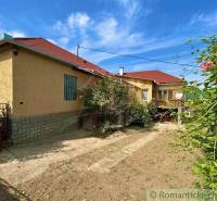 A family house in Gemerská Hôrka with a garden, flowers, and a blue sky.