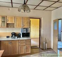 A kitchen in a family house with built-in wooden cabinets and kitchen appliances.