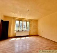 A bright room with laminate flooring and a large window in a family house.