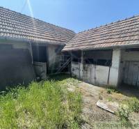 The yard of a family house in Nové Zámky with grass and an old roof.