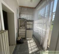 Hallway with a refrigerator, curtains, and a radiator in a family house.