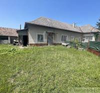 A family house in Nové Zámky with a large grassy garden and an adjacent building.