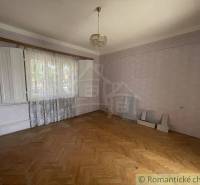 An empty room with a wooden floor and an open window in a family house.