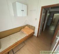 A simple room with a bed and a cabinet in a family house.
