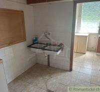 A kitchen in a family house with a tiled floor and a classic ceramic sink.