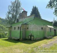 A family house in Poltár with a green facade, surrounded by nature and a peaceful environment.