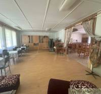 Interior of a family house with a dining area and tables for seating.