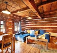 A wooden interior of a cabin with a blue couch and a wooden table.