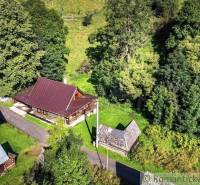 Aerial view of a wooden cabin near Kežmarok in a forested area.
