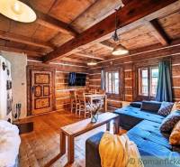 Wooden interior of a cabin with a sofa, table, and traditional details.