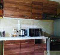 A kitchen in a cottage with a wooden kitchen unit, an electric kettle, and a microwave.