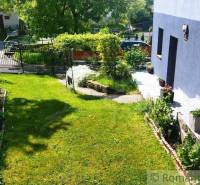 A garden at a family house in Spišská Nová Ves with greenery and a driveway.