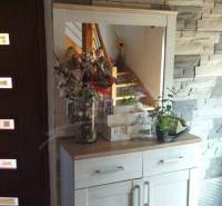 Mirror wall with a sideboard, lamp, and decorations in a family house.