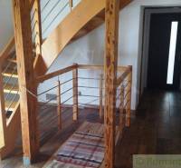 Interior of a family house with a wooden staircase and a dark plank floor.