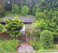 A family house in Ružomberok surrounded by lush greenery and dense forest.