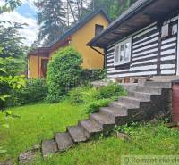 A traditional family house in Ružomberok surrounded by greenery and a lush garden.