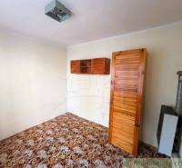 A room in a family house with cabinets, doors, decorated floor, simple furnishings.