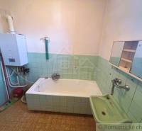 Bathroom in a family house with a bathtub, gas boiler, and mirror with a cabinet.