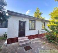 A family house in Plavecký Štvrtok with a white facade and a garden surrounded by greenery.