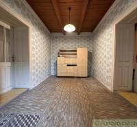Wooden ceiling paneling and patterned walls in the cabin create a cozy interior.