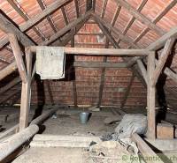 Attic space with old wooden structure and storage items in the cabin.