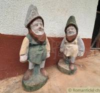 Stone dwarf statues at the cottage in Nové Zámky, on a concrete floor.
