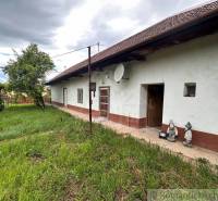 A cottage in Nové Zámky with a lawn, wooden doors, and two garden ornaments.
