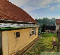 A family house in Žiar nad Hronom with a red roof and a manicured grassy garden.
